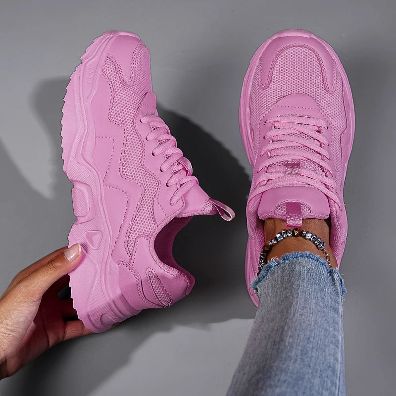 Pink women's mesh lace-up chunky sneakers shown from side and top view, worn with distressed jeans and bracelets.