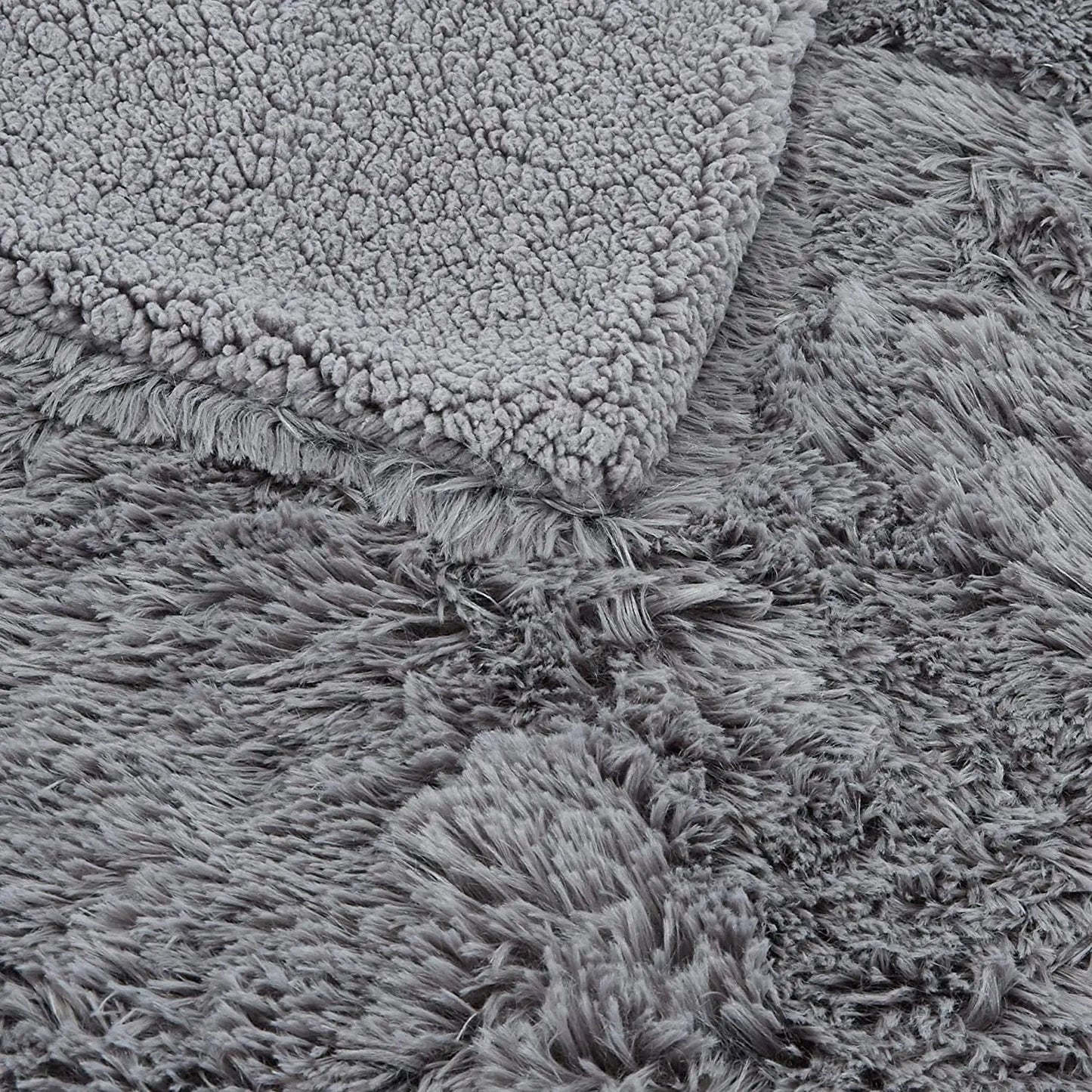 Gray faux fur plush throw blanket with fluffy shag texture, shown folded to display soft pile and backing detail.