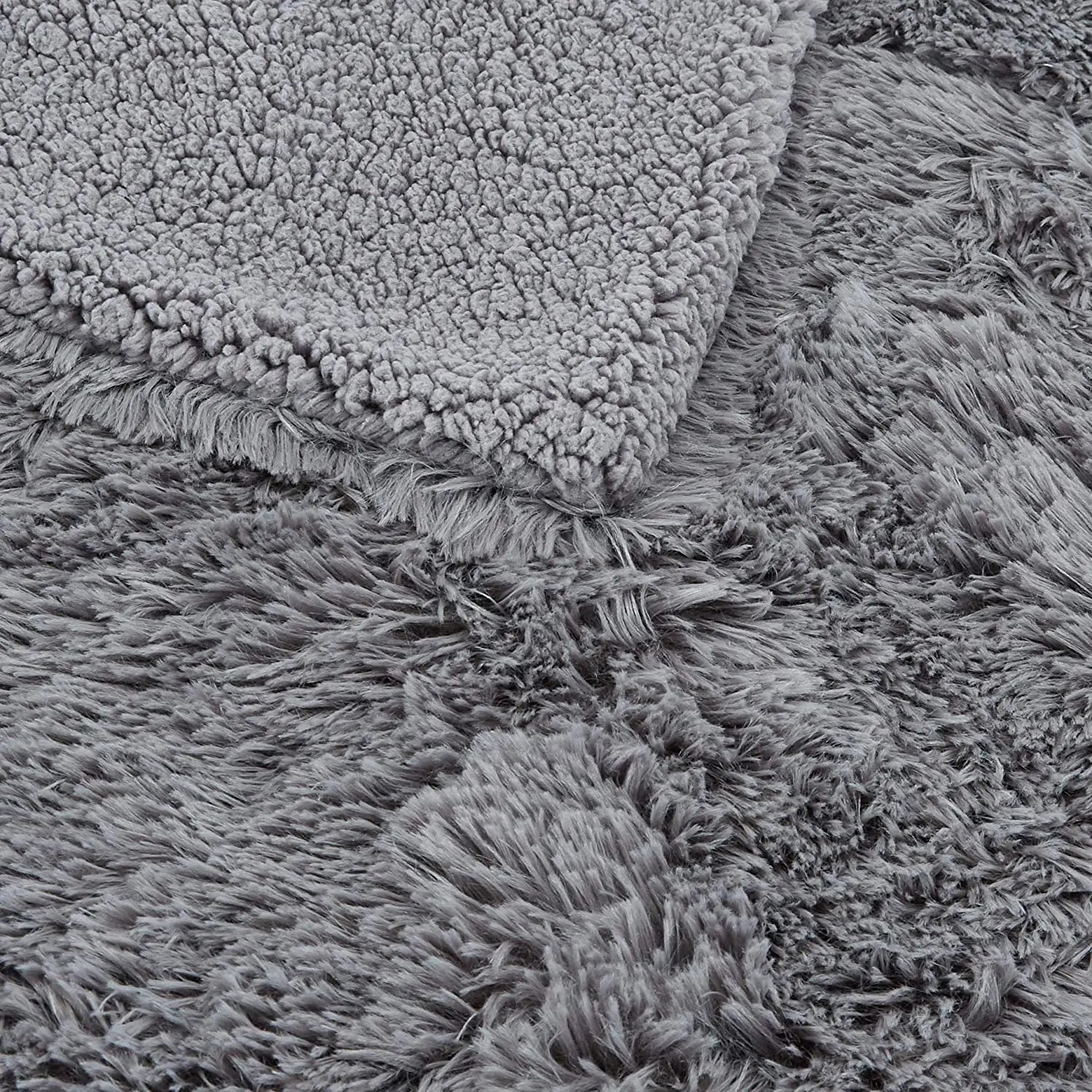 Gray faux fur plush throw blanket with fluffy shag texture, shown folded to display soft pile and backing detail.