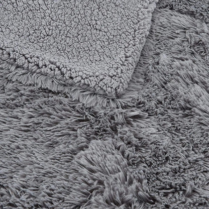 Gray faux fur plush throw blanket with fluffy shag texture, shown folded to display soft pile and backing detail.