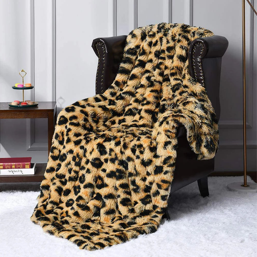 Luxurious leopard print faux fur throw blanket draped over dark leather armchair on white shag rug