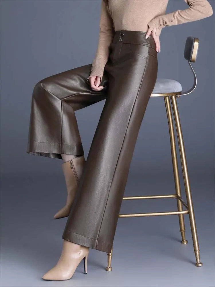 Women's high-rise wide-leg brown vegan leather pants styled with beige turtleneck and nude heels on bar stool