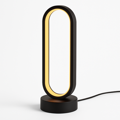 Black oval-shaped LED desk lamp with warm golden light strip on circular base, modern minimalist design, power cord visible.