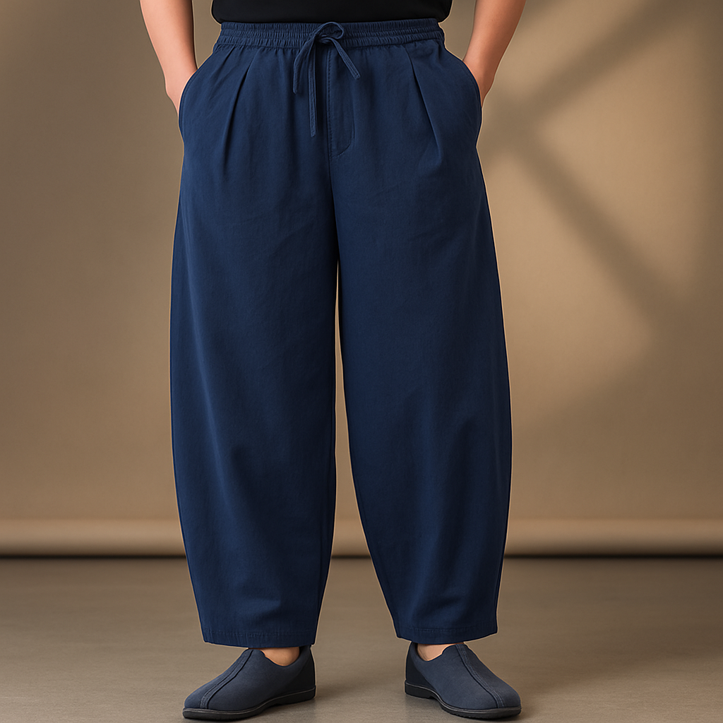 Navy blue wide-leg linen drawstring pants with elastic waist, relaxed fit, and tapered ankles, paired with slip-on shoes.