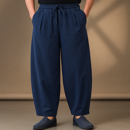 Navy blue wide-leg linen drawstring pants with elastic waist, relaxed fit, and tapered ankles, paired with slip-on shoes.
