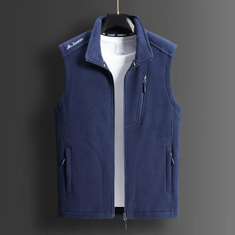 Navy blue men's fleece zip-up vest with stand collar, chest pocket, and side pockets, displayed on hanger over white tee.