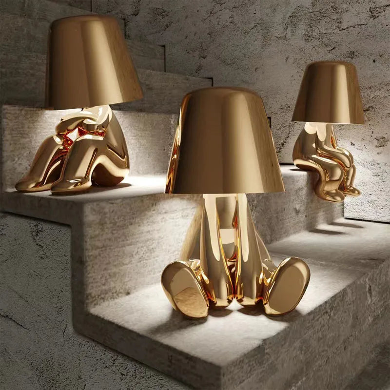 Gold dog figurine table lamp with metallic shade on concrete steps, decorative ambient lighting for modern interior design