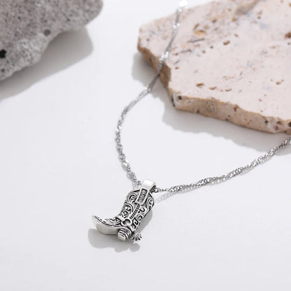 Silver necklace with intricate filigree Western cowboy boot charm pendant featuring spur detail on twisted chain