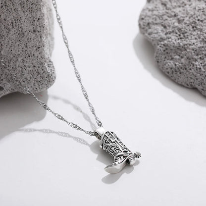 Silver necklace with intricate filigree western cowboy boot charm pendant on delicate twisted chain