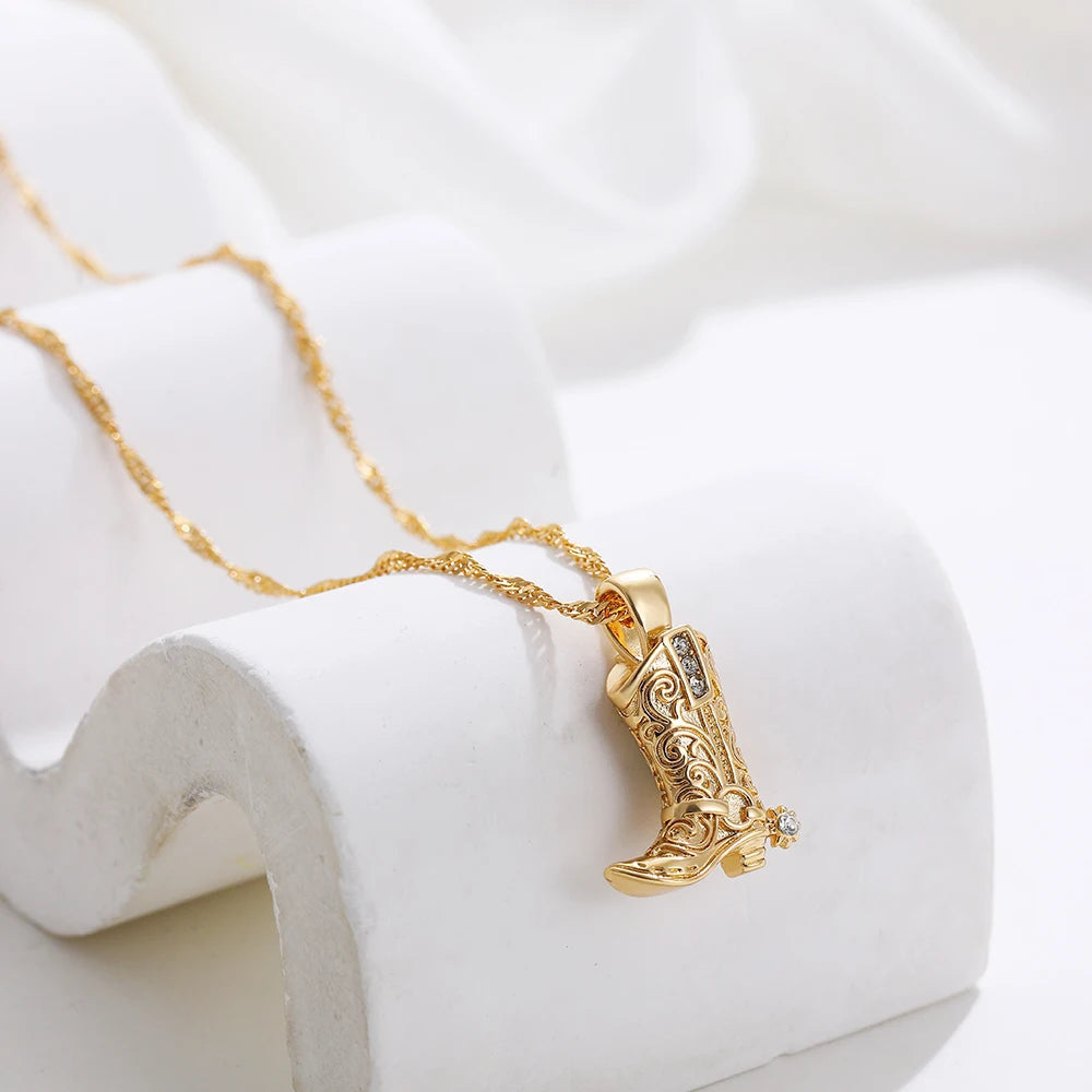 Gold necklace with intricate Western cowboy boot charm pendant featuring filigree details and crystal accents on twisted chain