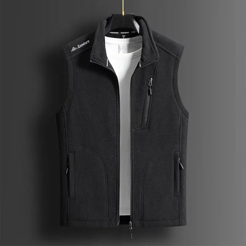 Dark gray men's fleece zip-up vest with stand collar, chest zip pocket, and side pockets, displayed on hanger.