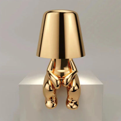 Gold metallic dog figurine desk lamp with lampshade head, sitting pose, reflective finish, on white pedestal