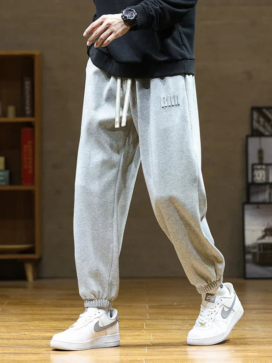 Men's gray drawstring sweatpants with elastic cuffs and embroidered logo, casual jogger style pants
