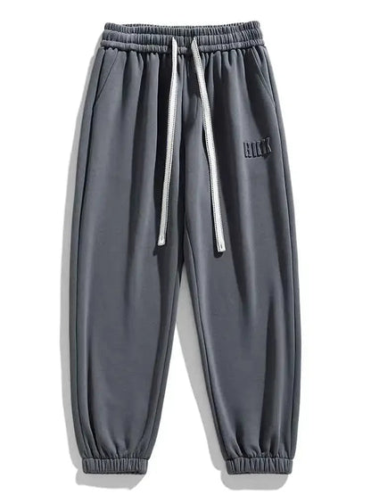 Gray men's drawstring sweatpants with elastic waistband, ribbed cuffs, side pockets, and embroidered logo detail.