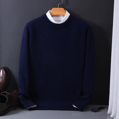 Navy blue men's cashmere blend crewneck sweater on hanger, layered over white collared shirt, styled with brown dress shoes.