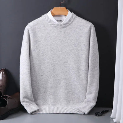 Light gray men's cashmere blend crewneck sweater on hanger, styled with white collar underneath, brown dress shoes nearby.
