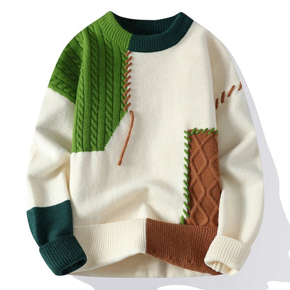 Men's color block cable knit wool sweater in cream, green, and brown patchwork design with crew neck and ribbed cuffs.