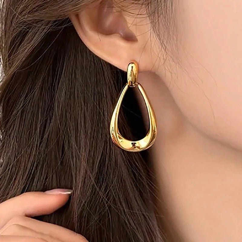 Gold teardrop dangle earrings for women with black enamel center and polished finish